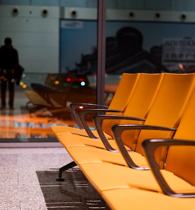 a row of yellow chairs sitting on top of a floor